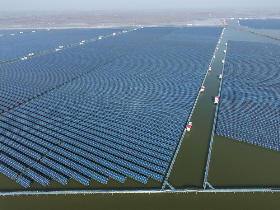 Aerial photo taken on Dec 24, 2016 shows a solar power project under construction in Cixi city, East China\'s Zhejiang province. The project, with solar panels installed above the fishery water, is expected to generate 220 million kwh of electricity per year.(Photo/Xinhua)