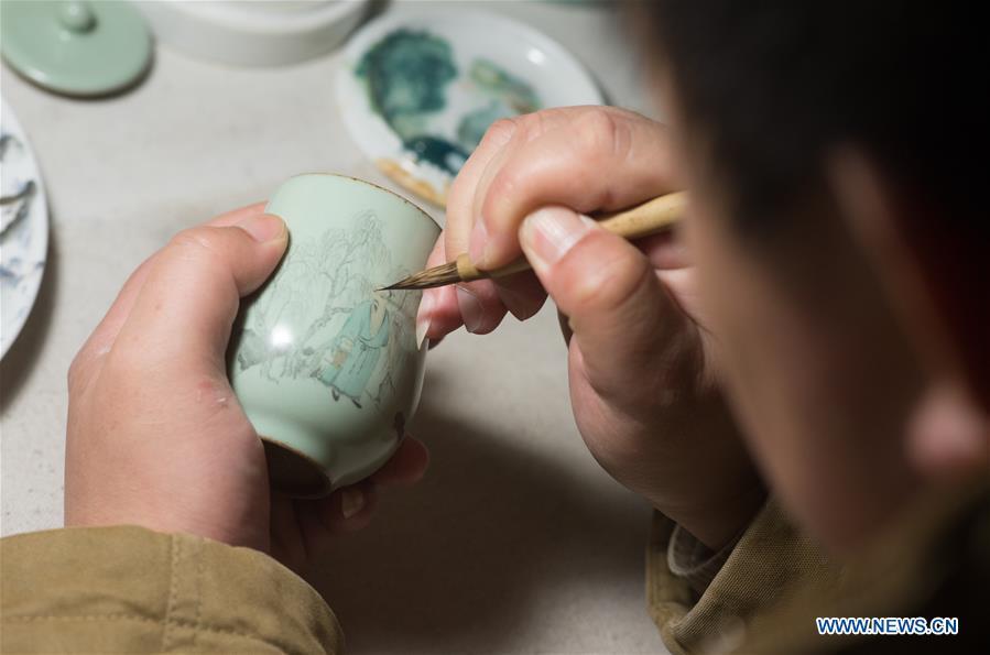 Artist Xiang Zhengyi creates traditional literati painting on a porcelain at the workshop in Jingdezhen, east China\'s Jiangxi Province, Dec. 23, 2016. (Xinhua/Weng Xinyang)