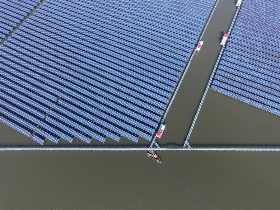 Aerial photo taken on Dec 24, 2016 shows a solar power project under construction in Cixi city, East China\'s Zhejiang province. The project, with solar panels installed above the fishery water, is expected to generate 220 million kwh of electricity per year.(Photo/Xinhua)