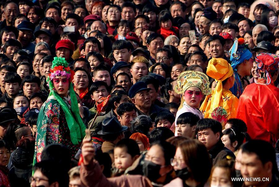
People watch performance of Shehuo at a temple fair in Junxian County, central China\'s Henan Province, Feb. 12, 2017. Shehuo is a folk entertainment popular in China. It can be traced back to ancient rituals to worship the earth, which people believe could bring good harvests and fortunes in return. (Xinhua/Li An)