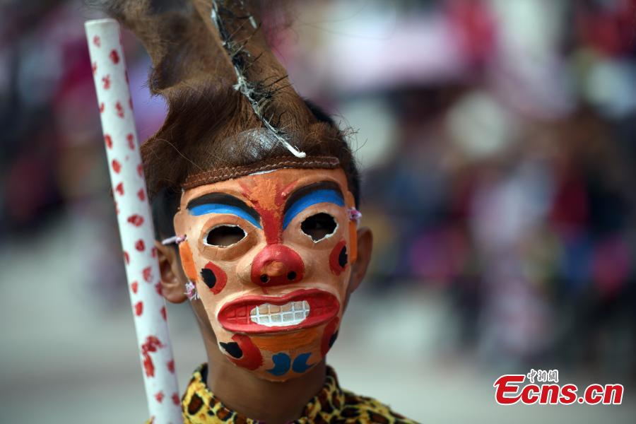 A Yi performer holds a sheng, a reed pipe wind instrument, during the opening ceremony of a tiger-themed cultural festival in Shuangbai County, Southwest China’s Yunnan Province, March 7, 2017. The tiger is the totem animal of the Yi people in the county. (Photo: China News Service/Li Jinhong)