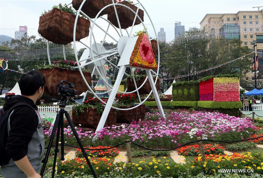 A reporter takes photos during the preview of the Hong Kong Flower Show at Victoria Park in Hong Kong, south China, March 9, 2017. The flower show will be held from 10 to 19 this March. (Xinhua/Li Peng)
