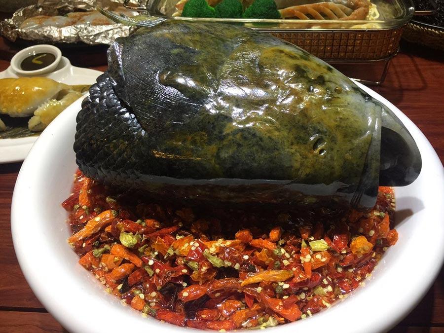 Emerald steamed fish head with diced chili peppers by carving master Zou Wantong. (Photo/China Daily)