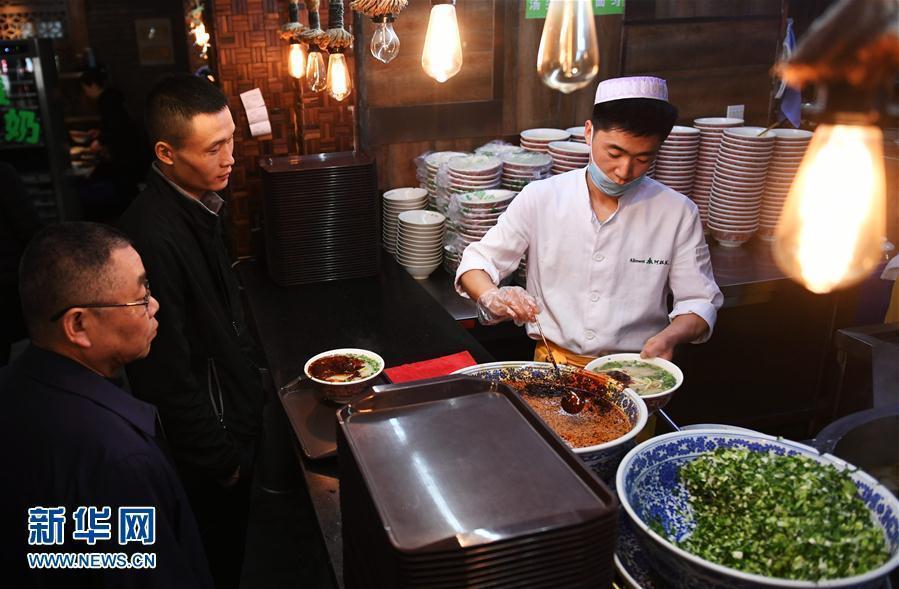 A cook adds chili oil to a bowl of beef noodles at a restaurant in Lanzhou City, capital of Northwest China’s Gansu Province, April 12, 2017. Lanzhou is known for its beef noodles made into different shapes. Thousands of restaurants in the city are reported to sell more than one million bowls of beef noodles a day. In many other cities in China people can also easily find beef noodle restaurants. (Photo: Xinhua/Chen Bin)