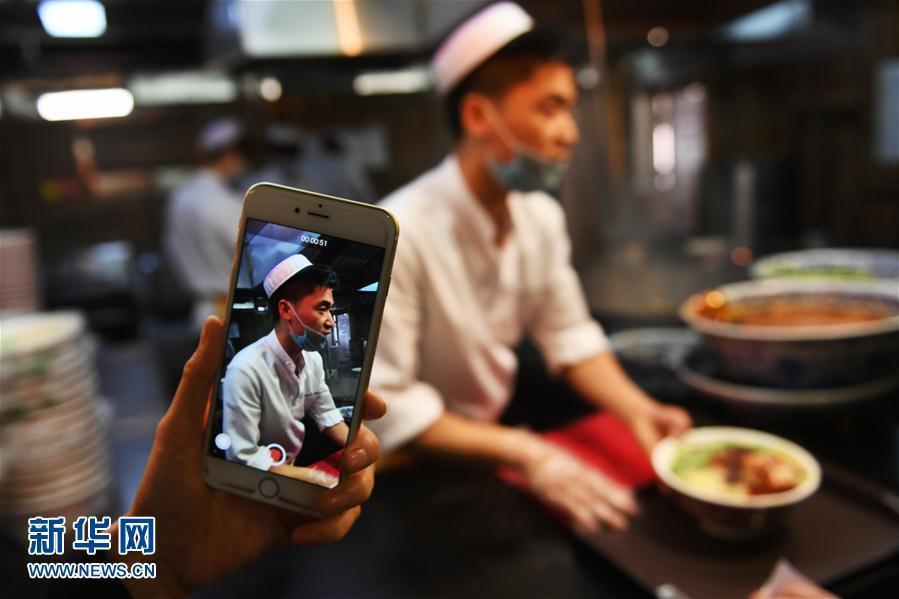 A tourist takes a picture of beef noodle preparation at a restaurant in Lanzhou City, capital of Northwest China’s Gansu Province, April 12, 2017. Lanzhou is known for its beef noodles made into different shapes. Thousands of restaurants in the city are reported to sell more than one million bowls of beef noodles a day. In many other cities in China people can also easily find beef noodle restaurants. (Photo: Xinhua/Chen Bin)