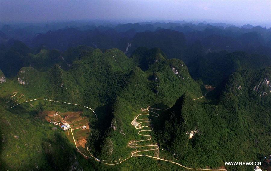 Aerial photo taken on May 25, 2017 shows a road linking Guwen Township and Liangmei Village in Dahua Yao Autonomous County, south China\'s Guangxi Zhuang Autonomous Region. Guangxi strengthened road construction efforts in poor rural areas in recent years. (Xinhua/Huang Xiaobang)