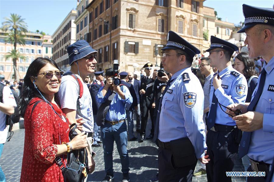 Chinese police officers talk with tourists at Piazza di Spagna of Rome, Italy, on June 5, 2017. A joint policing project between China and Italy was presented Monday in Rome\'s historic Piazza di Spagna. A group of 10 uniformed Chinese officers will be patrolling busy tourist areas in Rome, Florence, Naples, and Milan jointly with their Italian colleagues for the next 20 days. (Xinhua/Jin Yu)