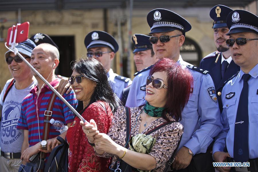 Tourists take a photo with Chinese and Italian police officers at Piazza di Spagna of Rome, Italy, on June 5, 2017. A joint policing project between China and Italy was presented Monday in Rome\'s historic Piazza di Spagna. A group of 10 uniformed Chinese officers will be patrolling busy tourist areas in Rome, Florence, Naples, and Milan jointly with their Italian colleagues for the next 20 days. (Xinhua/Jin Yu)