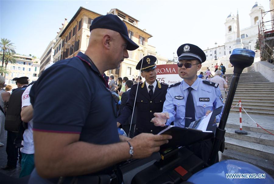 A Chinese police officer talks with an Italian police officer during their joint patrol at Piazza di Spagna of Rome, Italy, on June 5, 2017. A joint policing project between China and Italy was presented Monday in Rome\'s historic Piazza di Spagna. A group of 10 uniformed Chinese officers will be patrolling busy tourist areas in Rome, Florence, Naples, and Milan jointly with their Italian colleagues for the next 20 days. (Xinhua/Jin Yu)