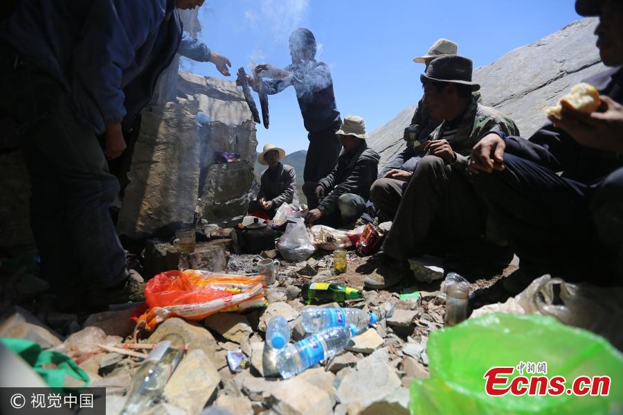 Locals mining inkstone have a simple lunch on a mountain in Gannan Tibetan Autonomous Prefecture, Northwest China’s Gansu Province. For generations, residents of Taoyan Township have collected Tao Inkstone, one of the four famous inkstones in China. They use basic tools including a hammer and ropes to mine the material on the mountain, then carry it along dangerous cliff roads. One can carry unprocessed inkstone up to 40 kilograms and it sells for about 30 yuan ($4.4) per kilogram. Mining inkstone and collecting herbs for medicine are two major income sources for locals. (Photo/VCG)