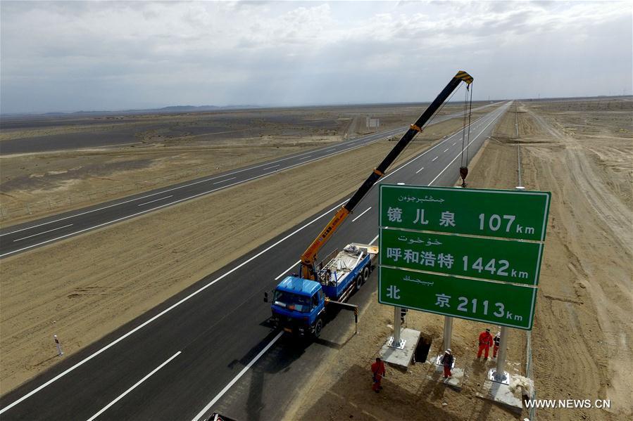 Workers set up a traffic sign at the Hami section of Beijing-Xinjiang Highway in Hami, northwest China\'s Xinjiang Uygur Autonomous Region, June 18, 2017. The Hami to Mingshui of Gansu section of Beijing-Xinjiang Highway was expected to open to traffic at the end of June. The open of Beijing-Xinjiang Highway will shorten a highway mileage of 1,000km from Beijing to Xinjiang. (Xinhua/Cai Zengle)