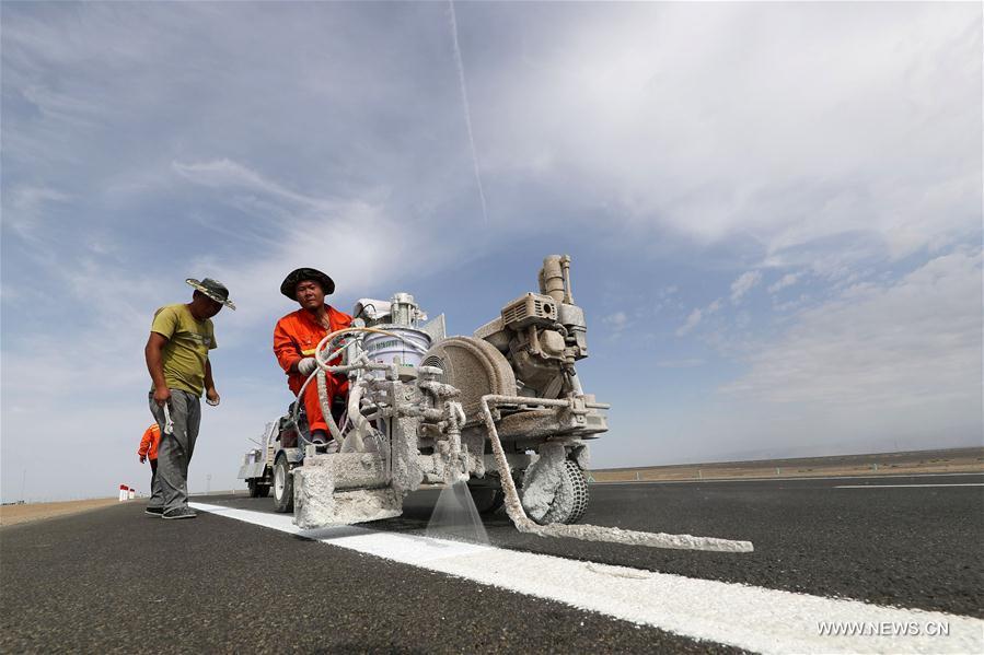 Workers draw highway markers at the Hami section of Beijing-Xinjiang Highway in Hami, northwest China\'s Xinjiang Uygur Autonomous Region, June 18, 2017. The Hami to Mingshui of Gansu section of Beijing-Xinjiang Highway was expected to open to traffic at the end of June. The open of Beijing-Xinjiang Highway will shorten a highway mileage of 1,000km from Beijing to Xinjiang. (Xinhua/Cai Zengle)