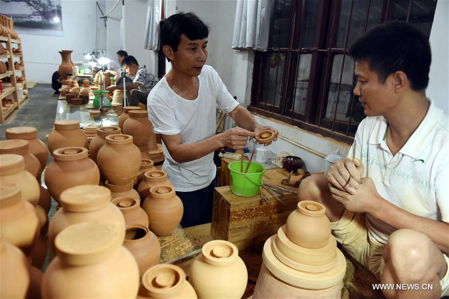 Intangible cultural heritage inheritor Feng Shaoxing instructs to make an unburned earthenware at a workshop at Jingdezhen, east China\'s Jiangxi Province, June 26, 2017. Jingdezhen has a history of porcelain-making that dates back more than 1,000 years. In the late Ming Dynasty (1368-1644), it was not only the home of imperial kilns, but also a center for porcelain exports. (Xinhua/Zhang Ruiqi)