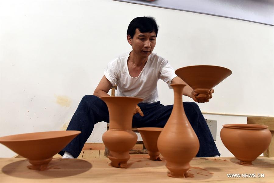 Intangible cultural heritage inheritor Feng Shaoxing makes an unburned earthenware at a workshop at Jingdezhen, east China\'s Jiangxi Province, June 26, 2017. Jingdezhen has a history of porcelain-making that dates back more than 1,000 years. In the late Ming Dynasty (1368-1644), it was not only the home of imperial kilns, but also a center for porcelain exports. (Xinhua/Zhang Ruiqi)