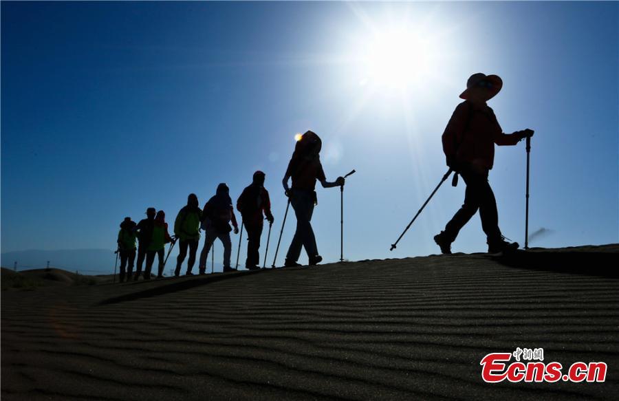 Hikers traverse the Gobi Desert near Zhangye City, Northwest China’s Gansu Province on July 16, 2017. Despite air temperatures of 38 degrees centigrade and ground temperatures of 50 degrees centigrade, 307 people from 11 provinces and cities undertook a 10-km hike across the searing sand. (Photo: China News Service/Wang Jiang)
