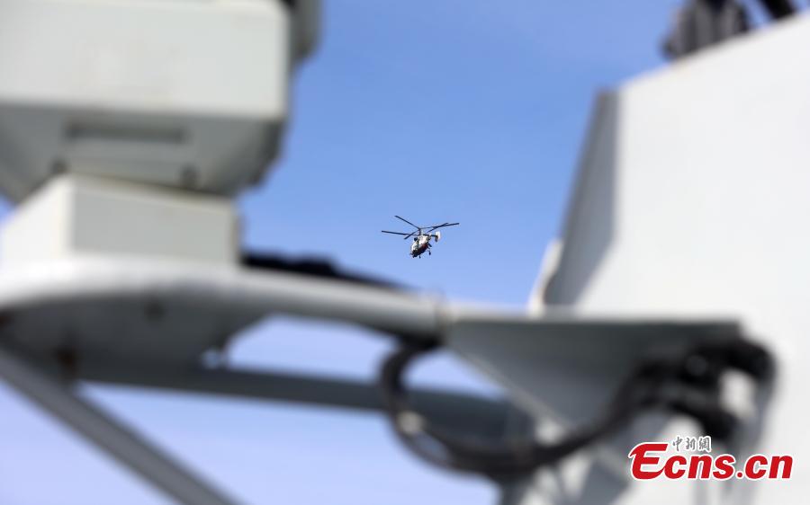 A helicopter flies past a Chinese Navy destroyer during a drill with Russia in the Baltic Sea, July 25, 2017. Chinese and Russian warships went into formations to protect against air attack during the drill. (Photo: China News Service/Wang Xiujun)