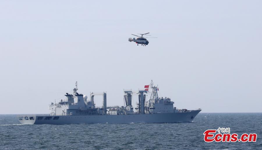 A helicopter flies past Chinese Navy destroyer Hefei during a drill with Russia in the Baltic Sea, July 25, 2017. Chinese and Russian warships went into formations to protect against air attack during the drill. (Photo: China News Service/Wang Xiujun)