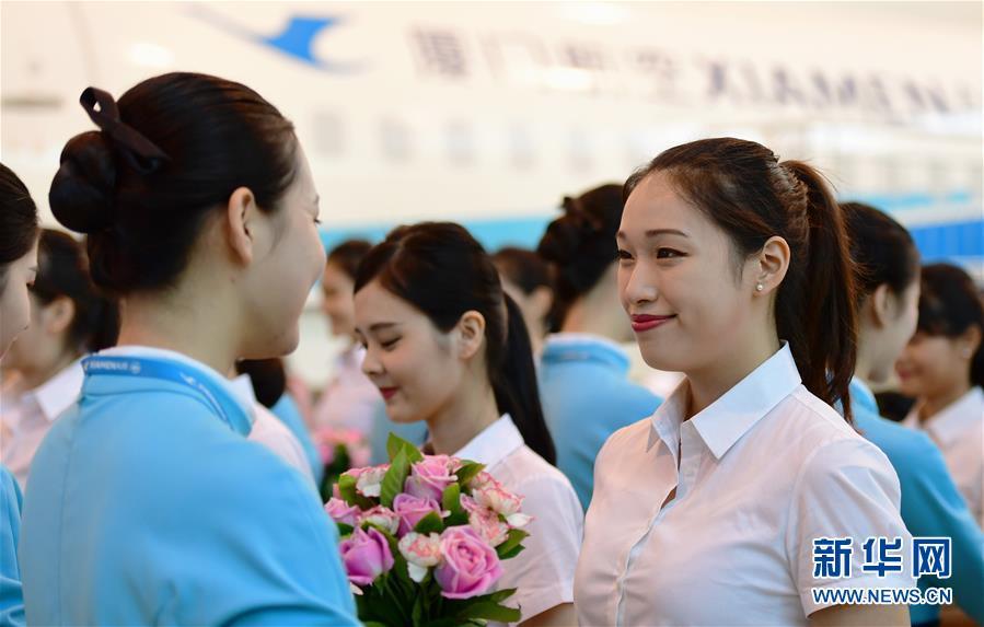 The new cabin crew from Taiwan (right) receive welcome flowers from existing Xiamen Airlines staff, Aug 16, 2017. (Photo/Xinhua)