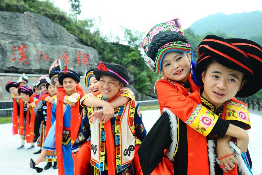 Seven couples take part in a group wedding in the traditional Qiang ethnic group costumes in Ningqiang county, Shaanxi Province, Aug. 27, 2017. (Photo/Xinhua)