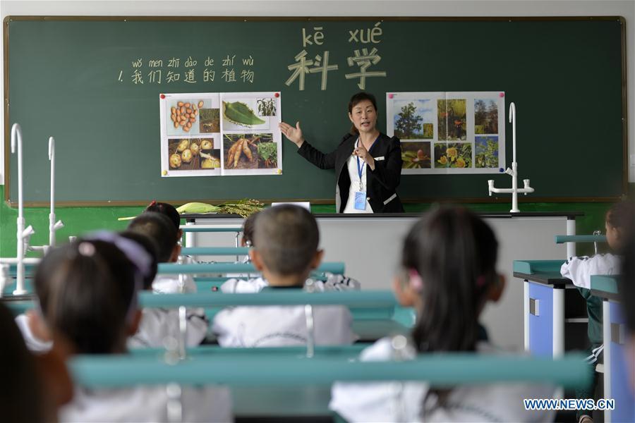 Science teacher Song Lihong introduces plants to first-year students at Liucun Primary School in Liucun Village of Xingtai City, north China\'s Hebei Province, Aug. 31, 2017. Since the beginning of this semester, primary schools across China have started to offer the science course to the first-year students. (Xinhua/Chen Lei)
