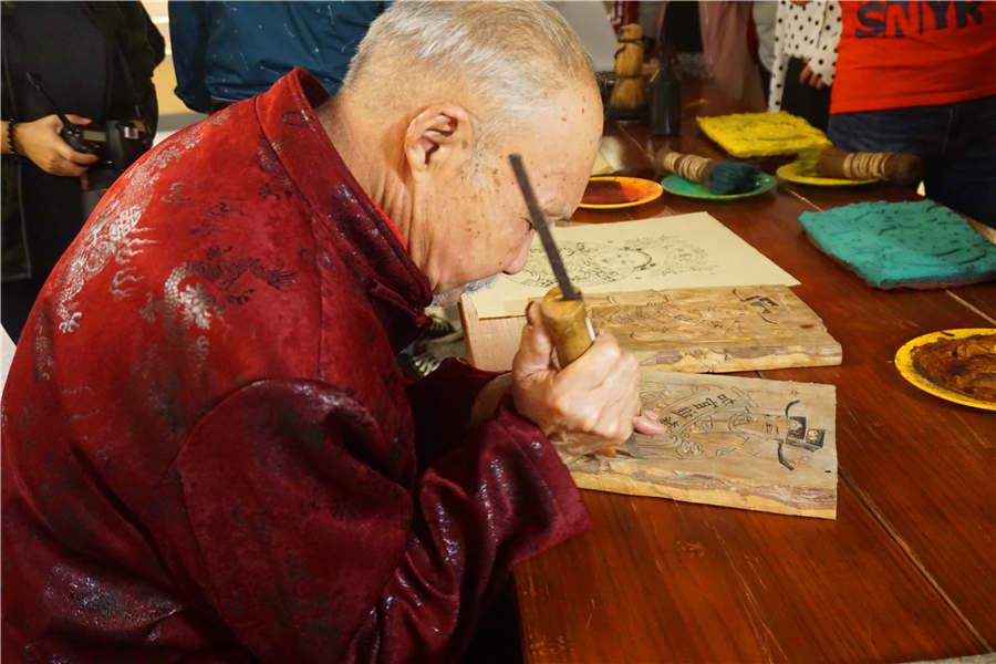Chen Yiwen carves on a woodblock in his workshop. (Photo/chinadaily.com.cn)