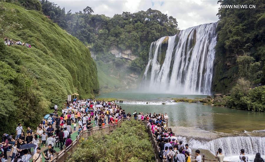 Tourists visit the Huangguoshu Waterfall in Anshun City, southwest China\'s Guizhou Province, Oct. 2, 2017. China witnessed more than 710 million tourist trips during the eight-day National Day and Mid-Autumn holidays, ringing up to about 590 billion yuan (88.68 billion U.S. dollars) in tourism income, according to the National Tourism Administration. (Xinhua/Chen Xi)