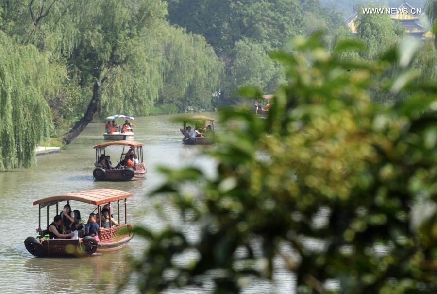 Tourists enjoy themselves at the Slender West Lake Scenic Area in Yangzhou, east China\'s Jiangsu Province, Oct. 8, 2017. China witnessed more than 710 million tourist trips during the eight-day National Day and Mid-Autumn holidays, ringing up to about 590 billion yuan (88.68 billion U.S. dollars) in tourism income, according to the National Tourism Administration. (Xinhua/Pu Liangping)