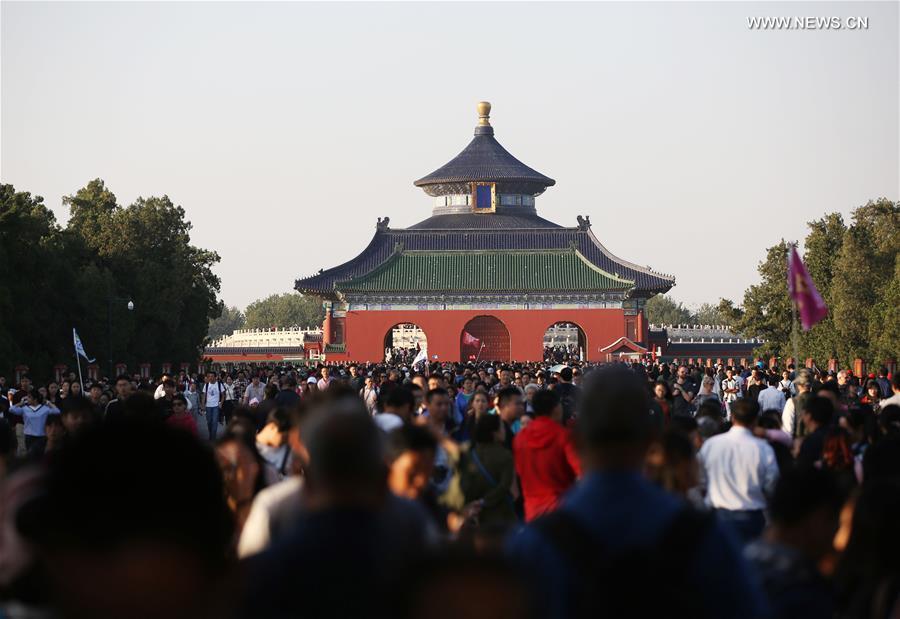 Tourists visit the Tiantan Park in Beijing, capital of China, Oct. 4, 2017. China witnessed more than 710 million tourist trips during the eight-day National Day and Mid-Autumn holidays, ringing up to about 590 billion yuan (88.68 billion U.S. dollars) in tourism income, according to the National Tourism Administration. (Xinhua/Tao Ye)