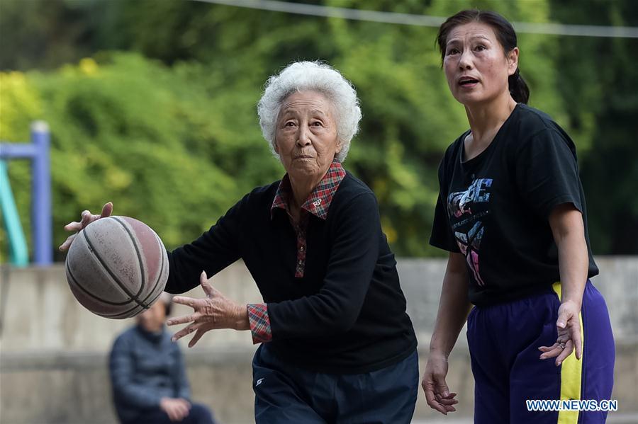 Yue Jingxia (L) plays basketball at a community in Hefei, capital of east China's Anhui Province, Oct. 26, 2017. Yue, 81 years old, fell in love with basketball when she was a little girl, and learnt to do yoga in 2000. Sports has been part of her life, and she wants to recommend her positive lifestyle to others. (Xinhua/Zhang Duan)