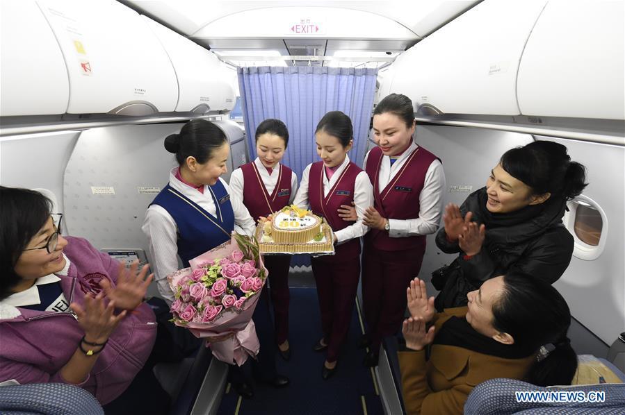 Cabin crew present bouquet and cake celebrating Zhu Aijun's (2nd L) 30-year-flight in the cabin in Shenyang, capital of northeast China's Liaoning Province, Nov. 17, 2017. Zhu Aijun has been a flight attendant in China Southern Airlines since 1987, and Friday is her last flight before retirement. Her daughter Li Xinyun, who became a flight attendant in 2016, has been permitted to fly with her mother. (Xinhua/Long Lei)