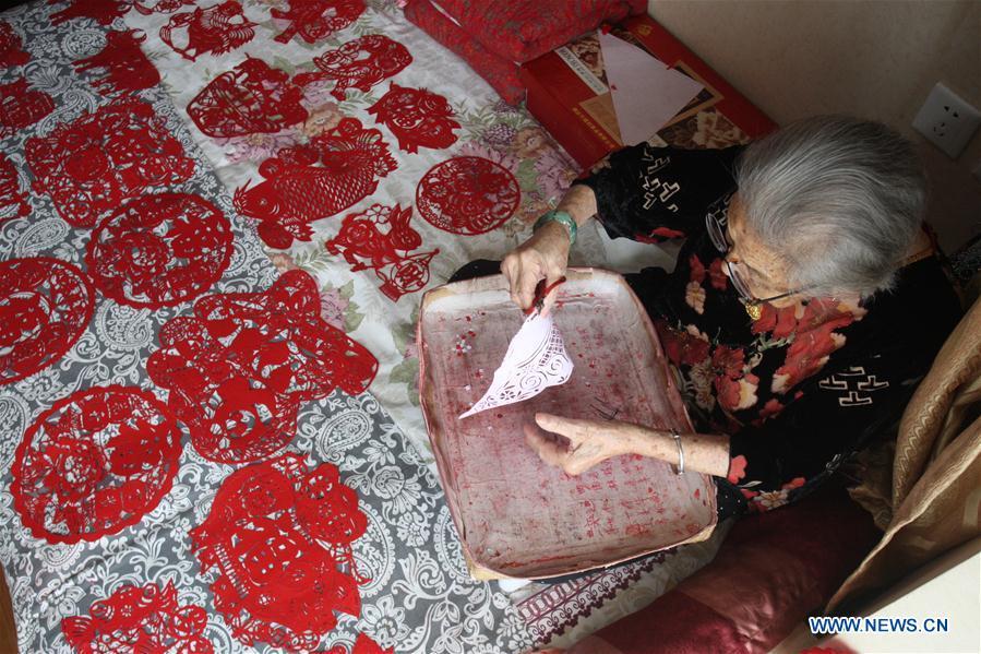 Lin Guimao, 103, makes papercuttings at home in Yantai City, east China's Shandong Province, Aug. 30, 2017. Lin learned papercutting skills as a child, and now still enjoys the hobby. (Xinhua/Shen Jizhong)