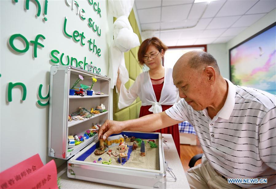 An elderly plays the Sandplay, a psychological game, at a daycare center of Yuxin Community in Taocheng District, Hengshui City, north China's Hebei Province, Aug. 3, 2017. Eight daycare centers for the elderly have been established to provide older people with food, entertainment, counselling and physical health care since 2016 in Taocheng District. (Xinhua/Mu Yu)