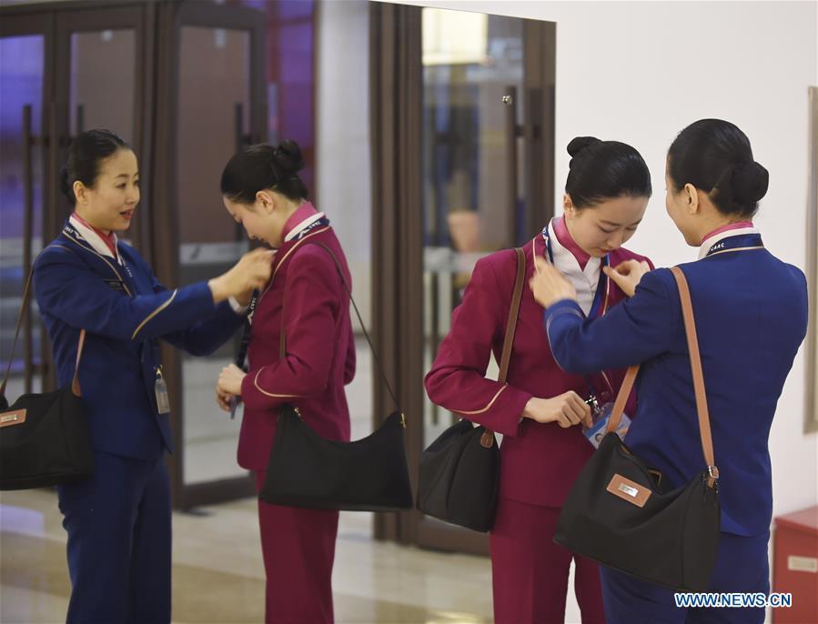 Zhu Aijun (R) helps her daughter Li Xinyun with uniform in Shenyang, capital of northeast China's Liaoning Province, Nov. 17, 2017. Zhu Aijun has been a flight attendant in China Southern Airlines since 1987, and Friday is her last flight before retirement. Her daughter Li Xinyun, who became a flight attendant in 2016, has been permitted to fly with her mother. (Xinhua/Long Lei)