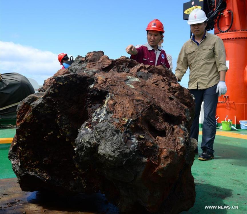 Expedition team members observe a sulfide sample collected from the south Atlantic on Nov. 30, 2017. Xiangyanghong 01, China's elite science ship, on Thursday collected the sulfide sample weighed around 3 tons, which is the biggest one of its kind in the country. (Xinhua/Zhang Xudong)