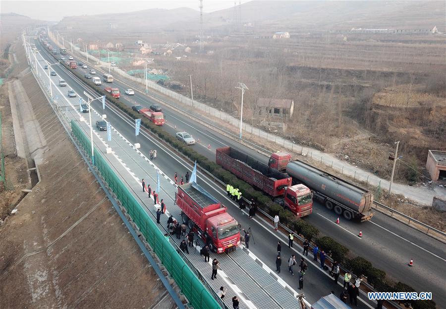 A heavy vehicle runs on a solar expressway in Jinan, capital of east China\'s Shandong Province, Dec. 28, 2017. China on Thursday opened a 1-km section solar expressway for testing. Solar panels are laid beneath part of a ring road surrounding Jinan. The road surface is made of a transparent, weight-bearing material that allows sunlight to penetrate. The panels, covering 5,875 square meters, can generate 1 million kwh of power in a year, enough to meet the everyday demand of around 800 households.(Xinhua/Zhu Zheng)