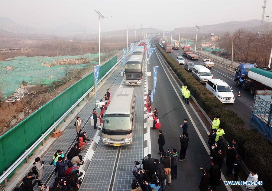 Vehicles run on a solar expressway in Jinan, capital of east China\'s Shandong Province, Dec. 28, 2017. China on Thursday opened a 1-km section solar expressway for testing. Solar panels are laid beneath part of a ring road surrounding Jinan. The road surface is made of a transparent, weight-bearing material that allows sunlight to penetrate. The panels, covering 5,875 square meters, can generate 1 million kwh of power in a year, enough to meet the everyday demand of around 800 households.(Xinhua/Zhu Zheng)