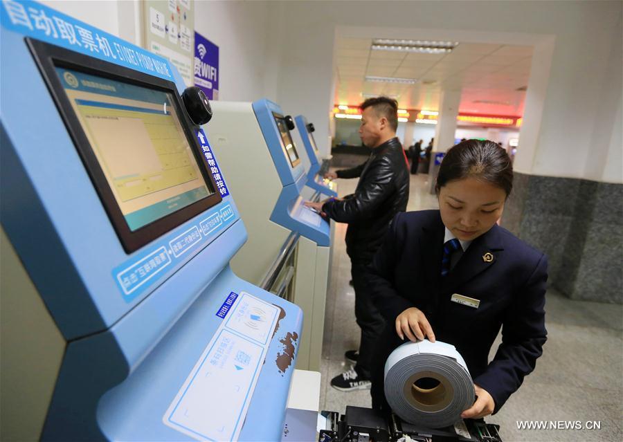 A staff member debugs a ticket vending machine at Kaili railway station in Kaili City, southwest China\'s Guizhou Province, Jan. 2, 2018. Train tickets for the Spring Festival travel rush go on sale on Jan. 3, 2018. China\'s transport system is often put to the test during the annual travel rush around the Spring Festival. The period is called \