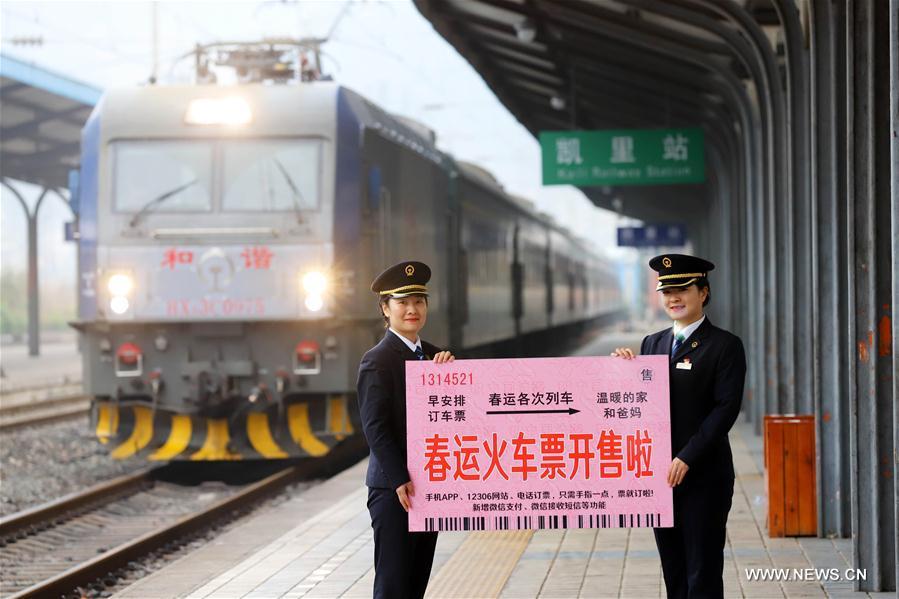 Staff members hold a poster reminding the sale of tickets for the Spring Festival travel rush at Kaili railway station in Kaili City, southwest China\'s Guizhou Province, Jan. 2, 2018. Train tickets for the Spring Festival travel rush go on sale on Jan. 3, 2018. China\'s transport system is often put to the test during the annual travel rush around the Spring Festival. The period is called \