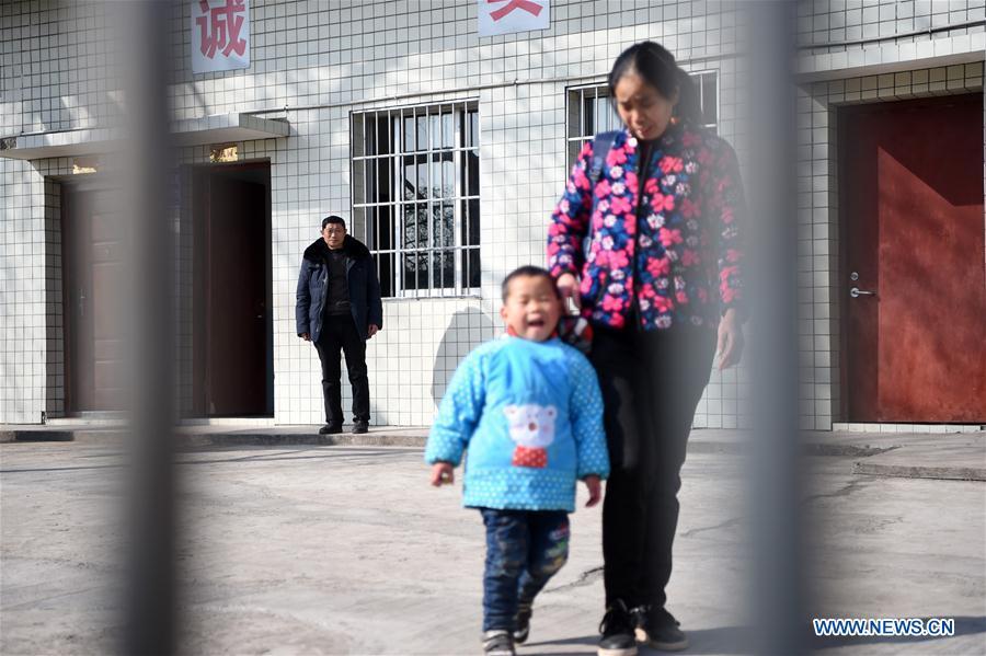 Tan Zeguang sees a student picked up by a parent at the Gaoshan Village Primary School in Tonggu Township of southwest China\'s Chongqing Municipality, Jan. 8, 2018. Tan Zeguang, a rural teacher of Gaoshan Village Primary School, has been teaching students in this remote area for a total of 40 years. Tan has to take care of both courses and daily life of students when they are at school, which is more than five kilometers away from the nearest town. In the past 40 years, more than 500 children were ever taught by Tan. As more students choose to attend better schools in towns, the school in which Tan stays has fewer students. But Tan still sticks to his post despite reaching retirement age. To his comfort, two young teachers have come to teach at the school and will continue his teaching career. (Xinhua/Tang Yi)