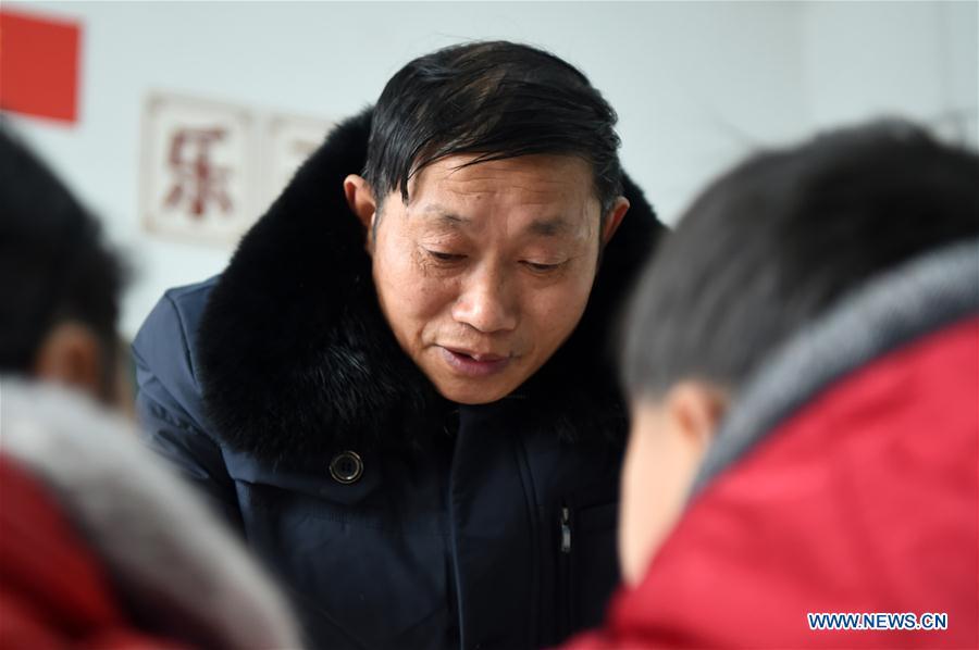 Tan Zeguang leads students to have a morning reading at the Gaoshan Village Primary School in Tonggu Township of southwest China\'s Chongqing Municipality, Jan. 8, 2018. Tan Zeguang, a rural teacher of Gaoshan Village Primary School, has been teaching students in this remote area for a total of 40 years. Tan has to take care of both courses and daily life of students when they are at school, which is more than five kilometers away from the nearest town. In the past 40 years, more than 500 children were ever taught by Tan. As more students choose to attend better schools in towns, the school in which Tan stays has fewer students. But Tan still sticks to his post despite reaching retirement age. To his comfort, two young teachers have come to teach at the school and will continue his teaching career. (Xinhua/Tang Yi)