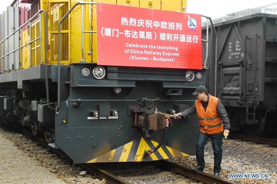 A staff member checks the freight train of China Railway Express (Xiamen-Budapest), linking southeast China\'s port city of Xiamen with Budapest, capital of Hungary, before its departure in Haicang Station in Xiamen, southeast China\'s Fujian Province, Jan. 19, 2018. The 11,595 km journey, which takes one stop at China\'s Xi\'an, will take 18 days.(Xinhua/Lin Shanchuan)