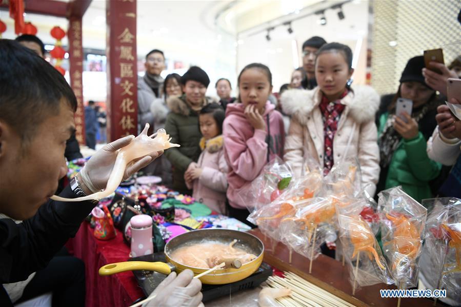People view the performance of sugar-figure blowing by a folk artist during a fair in Yinchuan, north China\'s Ningxia Hui Autonomous Region, Jan. 20, 2018, also the Great Cold (Dahan) solar term on the Chinese Lunar Calendar. (Xinhua/Wang Peng)