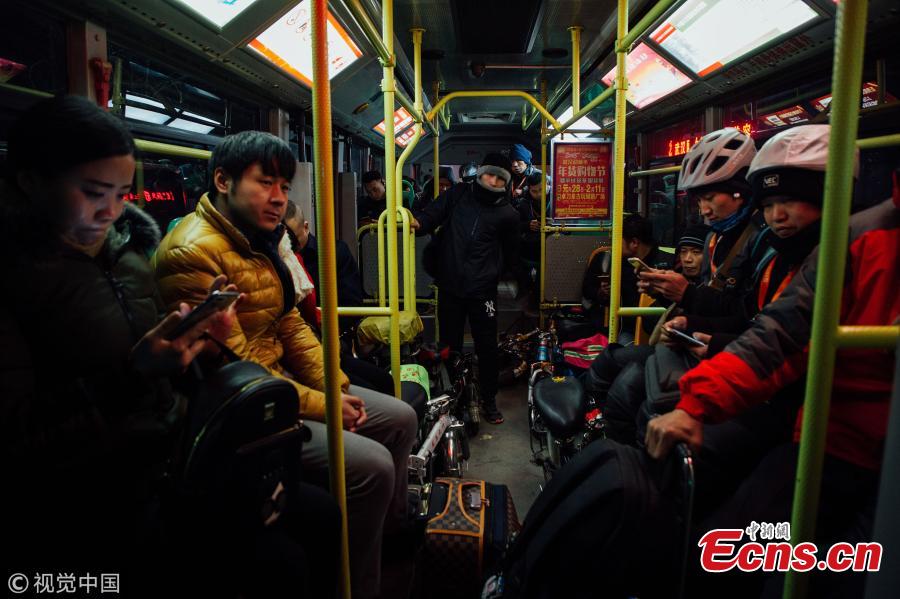 Passengers, mostly chauffeurs, ride a bus for free in Wuhan City, the capital of Central China’s Hubei Province, Feb. 7, 2018. Chauffeurs see an increase in demand for their services as more car owners drink more alcohol at dinners and parties ahead of Spring Festival, China’s Lunar New Year. Chauffeurs usually ride their folding bicycles to restaurants and entertainment venues, pick customers up there, and drive them home in their own cars. Some can earn up to 800 yuan ($120) over one night for the service. (Photo/VCG)