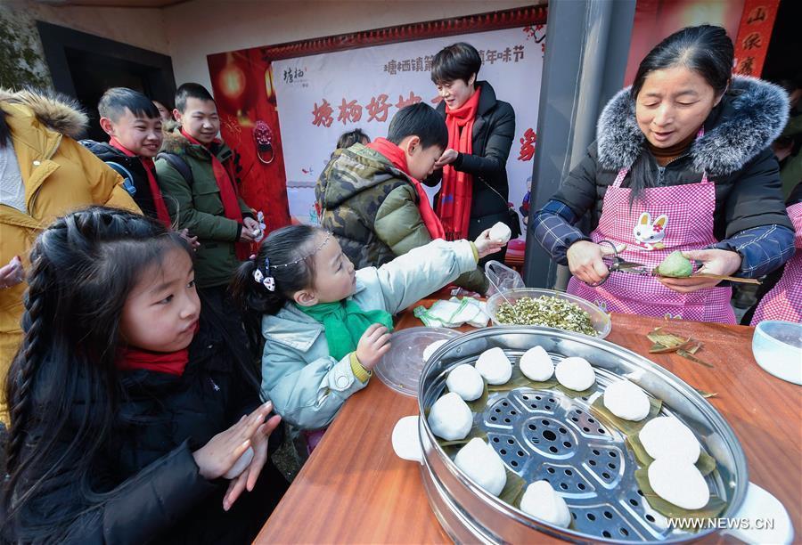 Children of migrant workers make glutinous rice wrap-up, in a celebrating activity in Tangqi ancient town in Hangzhou, capital of east China\'s Zhejiang Province, Feb. 8, 2018. Migrant workers take part in various folk activities with their children, who came from other cities for family gatherings, to celebrate the coming Spring Festival which falls on Feb. 16 this year. (Xinhua/Xu Yu)