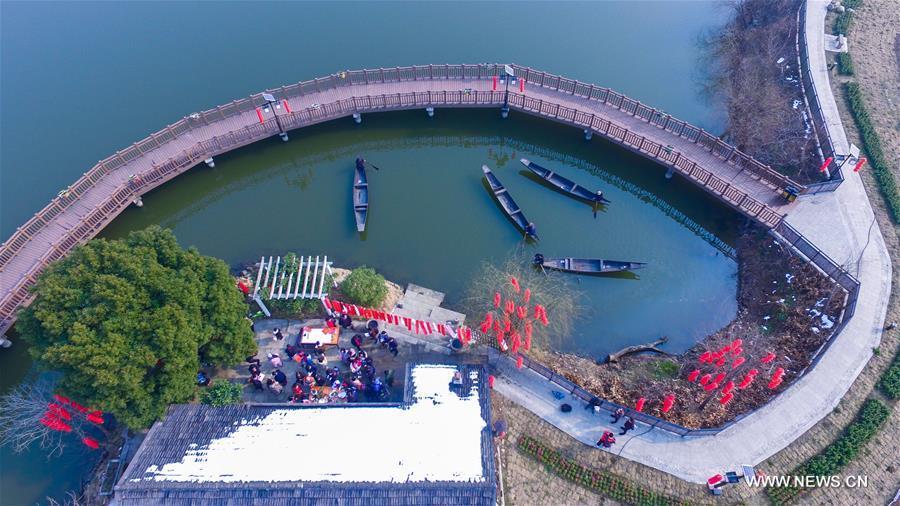 Photo taken on Feb. 8, 2018 shows the Tangqi ancient town with a festive atmosphere in a celebrating activity in Hangzhou, capital of east China\'s Zhejiang Province. Migrant workers take part in various folk activities with their children, who came from other cities for family gatherings, to celebrate the coming Spring Festival which falls on Feb. 16 this year. (Xinhua/Xu Yu)