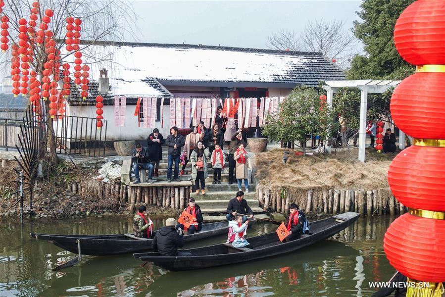 Children of migrant workers experience local folk customs in a celebrating activity in Tangqi ancient town in Hangzhou, capital of east China\'s Zhejiang Province, Feb. 8, 2018. Migrant workers take part in various folk activities with their children, who came from other cities for family gatherings, to celebrate the coming Spring Festival which falls on Feb. 16 this year. (Xinhua/Xu Yu)