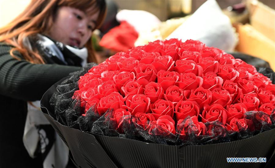 A vendor arranges roses at a flower market in Kunming, southwest China\'s Yunnan Province, Feb. 10, 2018. There are over 2,000 flower planting, processing, logistics and trading enterprises in Yunnan, with annual output value of 40 billion yuan (about 6.35 billion U.S. dollars). They have won over 70 percent market share in some 70 big and medium-sized cities in China and exported flower products to more than 40 countries and regions. (Xinhua/Lin Yiguang)