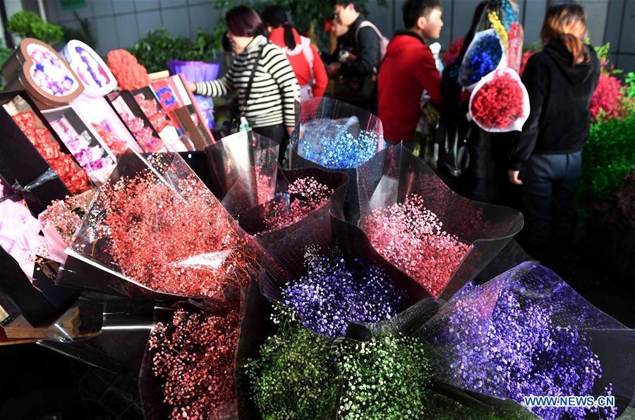 People buy flowers at a market in Kunming, southwest China\'s Yunnan Province, Feb. 10, 2018. There are over 2,000 flower planting, processing, logistics and trading enterprises in Yunnan, with annual output value of 40 billion yuan (about 6.35 billion U.S. dollars). They have won over 70 percent market share in some 70 big and medium-sized cities in China and exported flower products to more than 40 countries and regions. (Xinhua/Lin Yiguang)