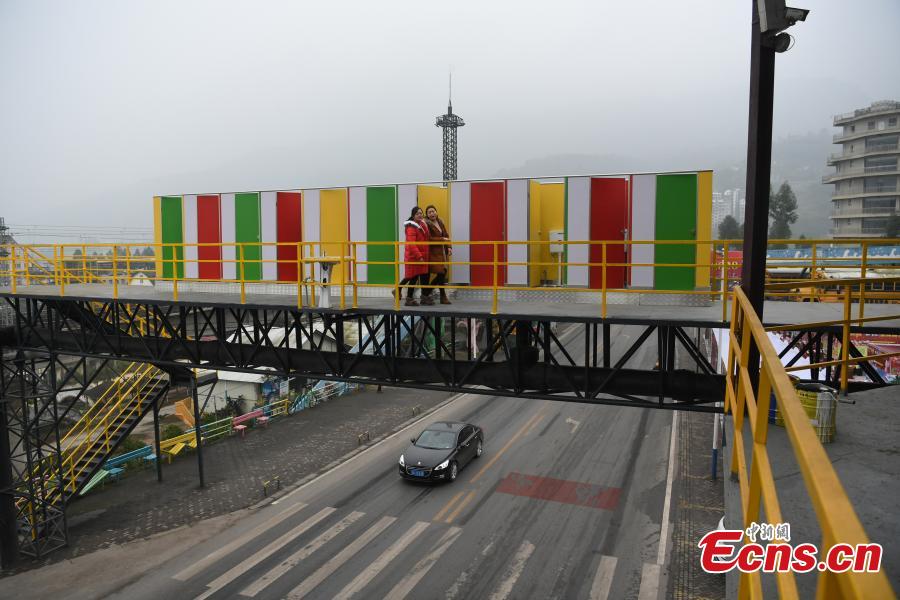 Temporary toilets are seen on a pedestrian skyway at a tourist spot in Fuling District, Southwest China’s Chongqing Municipality, Feb. 13, 2018. The unisex public toilets have been built for the increase in tourist numbers expected during the Spring Festival, China’s Lunar New Year. (Photo: China News Service/Chen Chao)