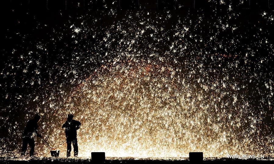 Sparks pour down as performers spray burning iron chips to shower sparks-like fireworks in Cixian County, north China\'s Hebei Province, Feb. 17, 2018. The performance was held to celebrate the Spring Festival, or the Chinese Lunar New Year, which fell on Feb. 16 this year. (Xinhua/Wang Xiao)